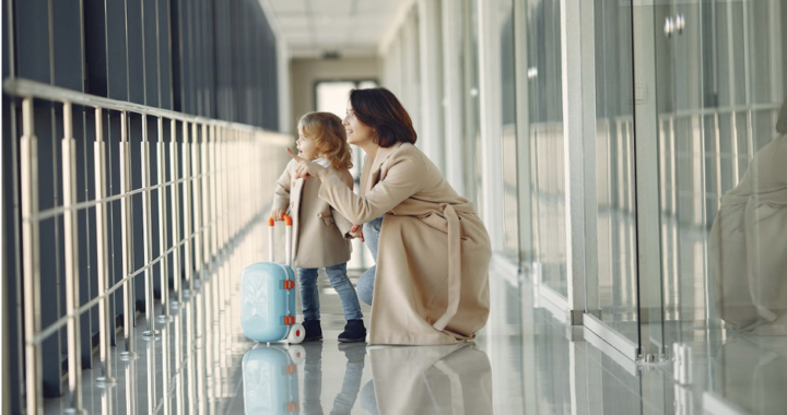 A delighted mother and her amazed daughter in an airport hallway, ready for their journey