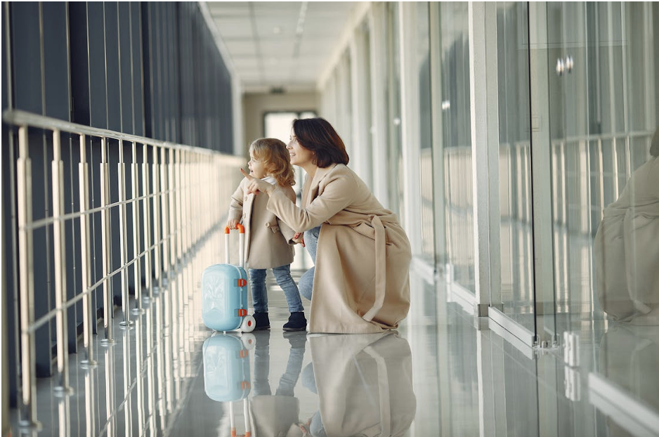 A delighted mother and her amazed daughter in an airport hallway, ready for their journey